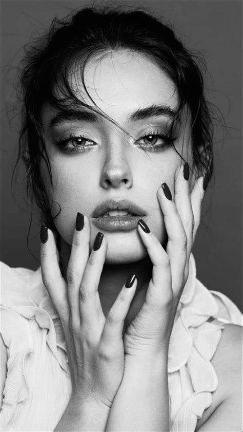 A Woman With Black And White Nail Polish Holding Her Hands To Her Face While Looking At The Camera