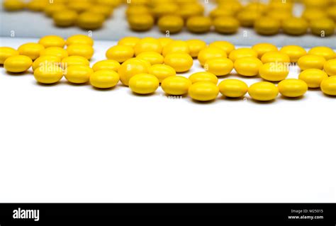 Macro shot detail of yellow round sugar coated tablets pills on blurred ...