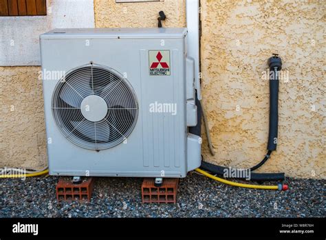 Mitsubishi Air Conditioning Exterior Unit Standing On 2 Bricks Stock