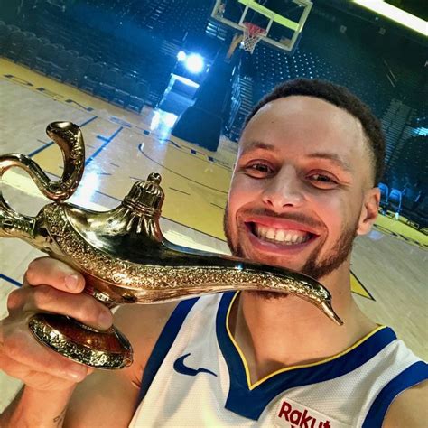 A Man Holding A Basketball Shoe And Trophy In Front Of His Face On A Court