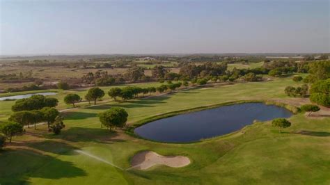 Campo de golf fairway lago y bunkers al atardecer vista aérea