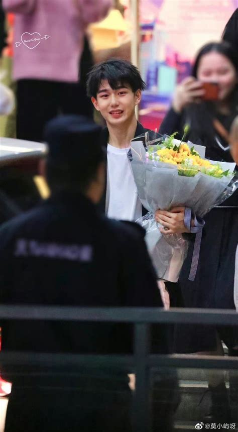 A Man Holding A Bouquet Of Flowers In His Hand While Walking Down The