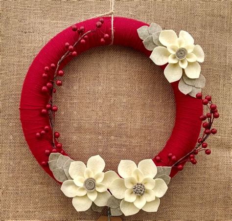 A Red Wreath With White Flowers On It