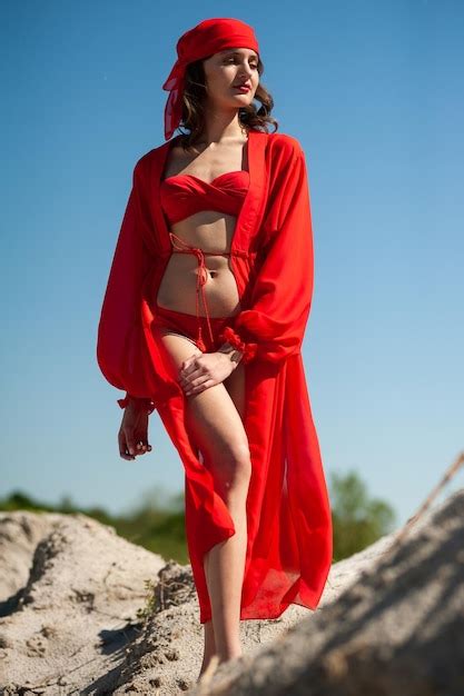 Una Mujer Con Un Vestido Rojo Se Encuentra En La Playa Foto Premium