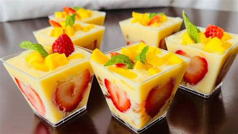 Four Desserts Are Arranged On A Table With Fruit In The Center And