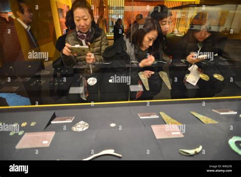 Chinese Visitors Look At Cultural Relics Excavated From The Tomb Of