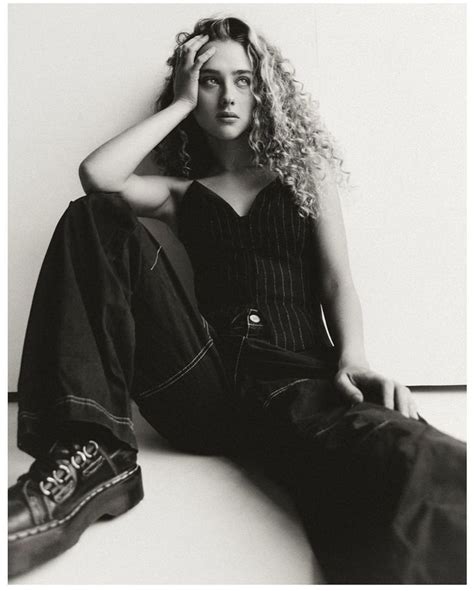 A Black And White Photo Of A Woman Sitting On The Floor