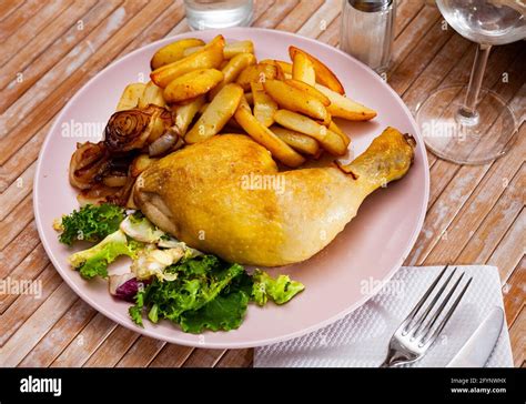 Cuisse de poulet rôtie servie sur une assiette avec accompagnement de