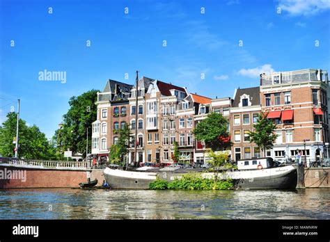 Canal Or Gracht In Amsterdam City Amstel River Scene With Boats And