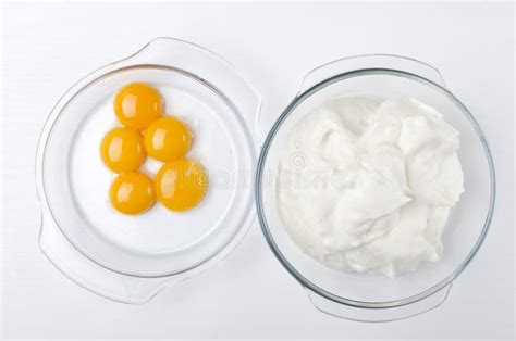 Top View Of Two Glass Bowls And Separated Yolk And Egg Whites On The