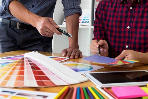 Graphic Designers Choose Colors From The Color Bands Samples For Design