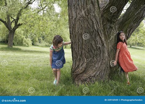 Girls Playing Hide And Seek By Tree Stock Image Image 33916949