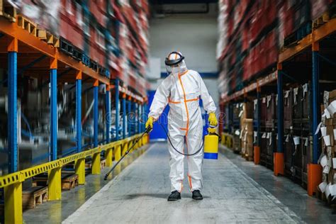 Man Worker With Protective Mask And Suit Disinfecting Industrial