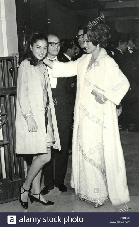 An Old Black And White Photo Of Two Women Standing Next To Each Other