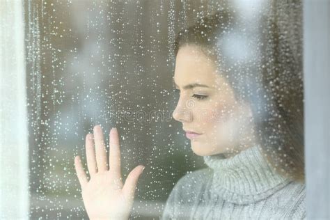 Sad Girl Looking through a Window in a Rainy Day Stock Photo - Image of ...