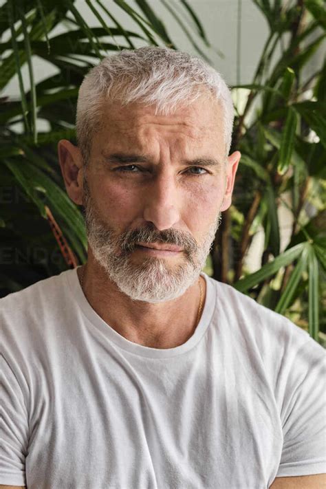 Handsome Mature Man With White Hair And Beard At Home Stock Photo