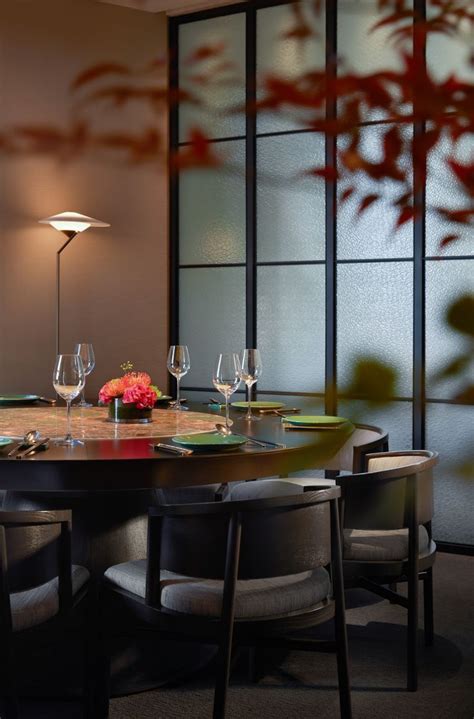 A Dining Room Table Set With Wine Glasses And Place Settings In Front