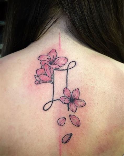 The Back Of A Womans Neck With Pink Flowers On It And A Line In The Middle