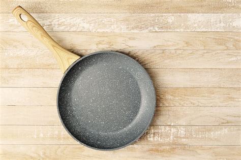 Empty Ceramic Frying Pan With Wooden Handle On Wooden Background Stock