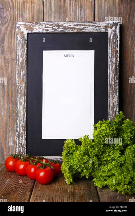 Menu board on rustic wooden planks background with cherry tomatoes and ...