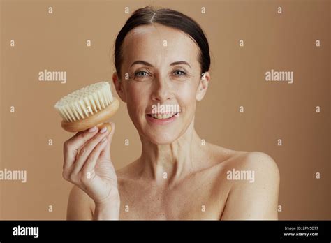 Smiling Modern 40 Years Old Woman With Massage Brush Isolated On Beige