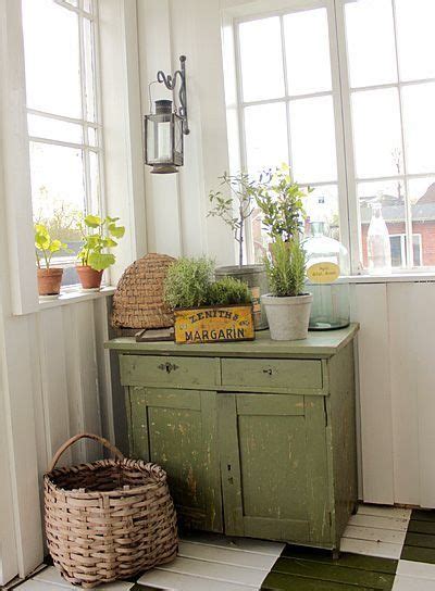 A Green Cabinet Sitting On Top Of A Checkered Floor Next To Two Potted