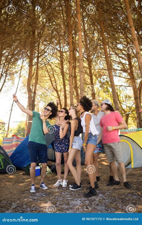 Full Length Of Cheerful Friends Taking Selfie At Campsite Stock Image