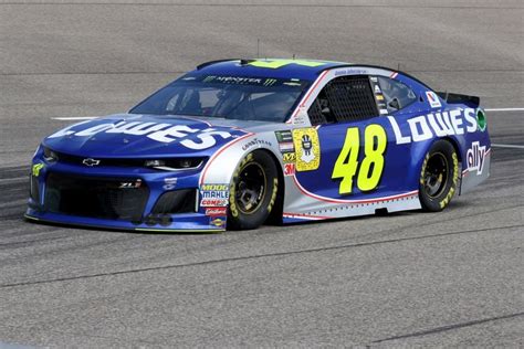 A Blue And White Car Driving On A Track With The Number Logo On It