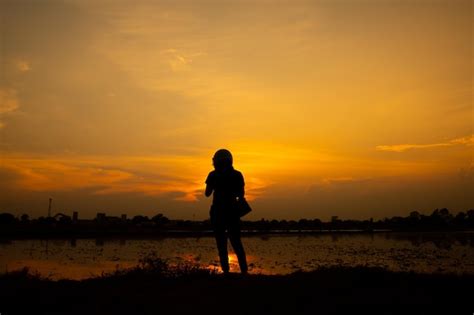 Premium Photo Silhouette Woman Standing On Shore Against Sky During