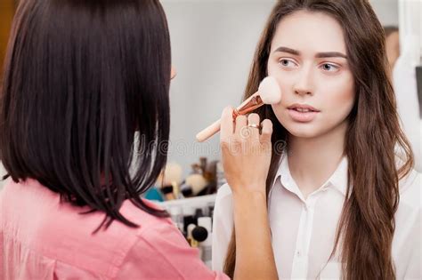 Make Up Artist Does Makeup To A Beautiful Girl In A Beauty Salon Stock