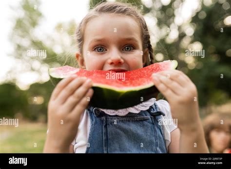 Cute Girl Eating Watermelon Standing At Park Stock Photo Alamy