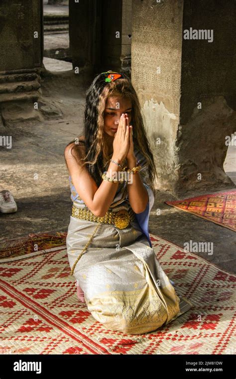 Cambodian Woman In Traditional Clothing Praying At Angkor Wat Angkor