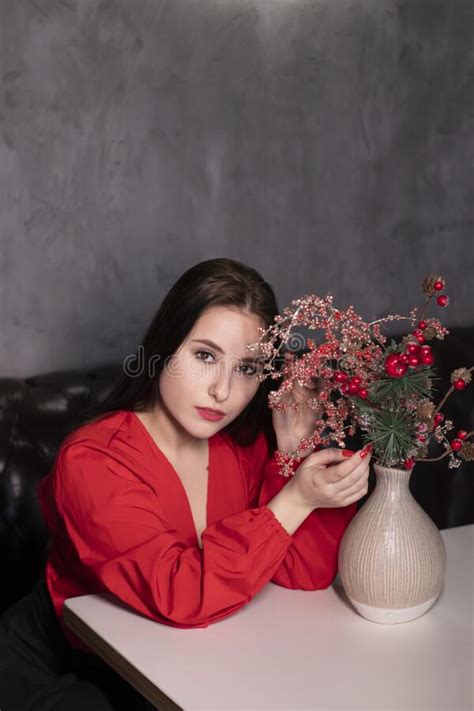 Attractive Brunette Woman In Red Blouse And Black Skirt In A Loft