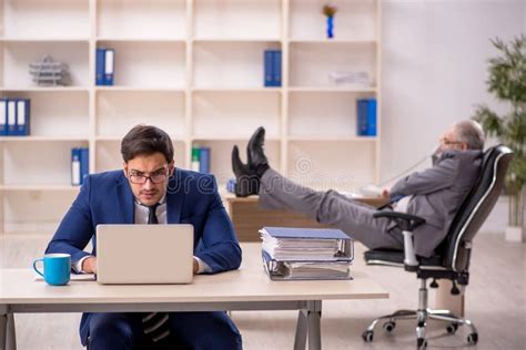 Jefe Masculino Viejo Y Empleado Joven En La Oficina Foto De Archivo