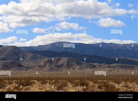 A Blue Cloudy Sky With Shadows On Distant Desert Mountains Stock Photo