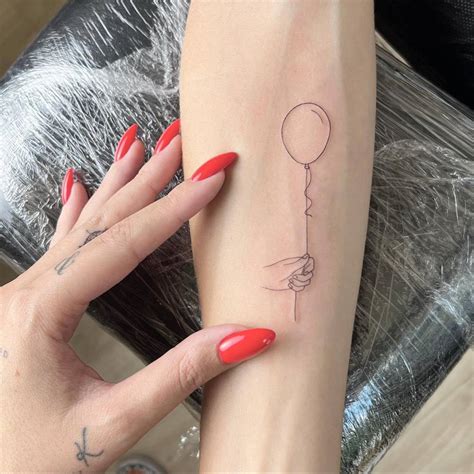 Fine Line Style Hand Holding Balloon Tattoo Done On The