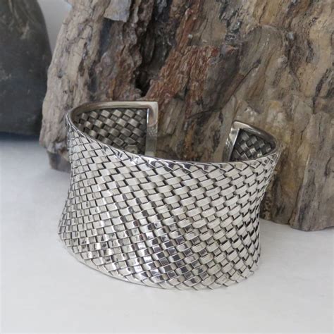 A Silver Cuff Bracelet Sitting On Top Of A Rock