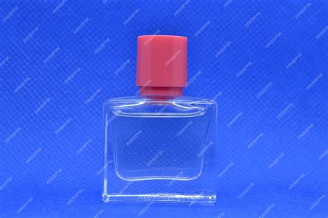 Una Botella De Perfume Con Una Tapa Roja Sobre Un Fondo Azul Foto