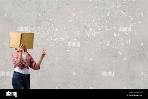 Teenager girl hiding her face behind book Stock Photo - Alamy