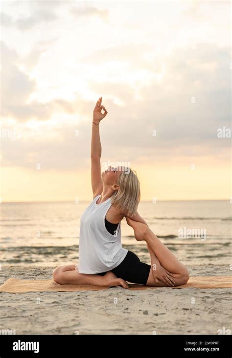 Woman Doing Yoga Mermaid Pose On Beach Stock Photo Alamy