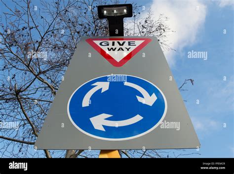 British Road Sign Indicating A Roundabout Ahead And Instructing Road