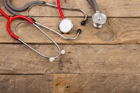 Premium Photo Grey And Red Stethoscopes On Wooden Desk