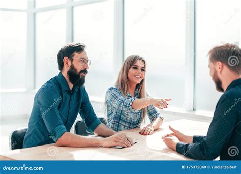 Group Of Successful Young People Sitting At The Negotiating Table