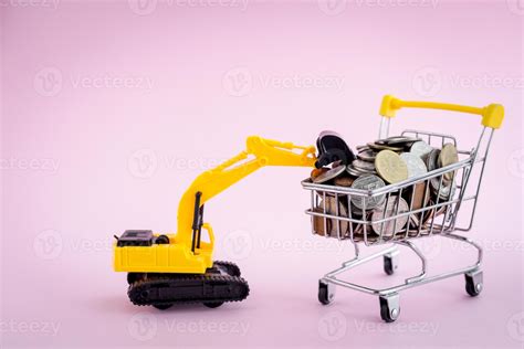 The Excavator Loader Model With Pile Of Coins In The Shopping Cart On Pink Background 37484589