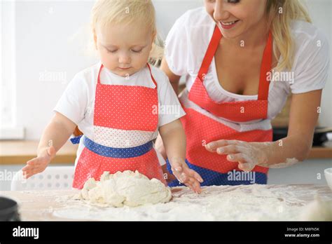 Petite Fille Et Sa Maman Blonde En Rouge Et Rire Tout En Jouant Des Tabliers Le P Trissage La