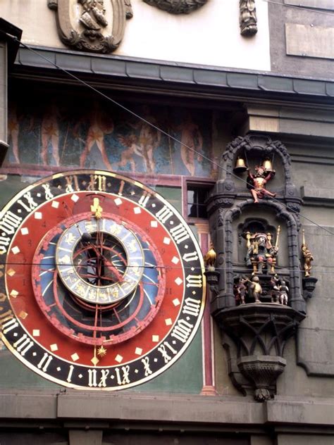 A Large Clock Mounted To The Side Of A Building With Roman Numerals On It