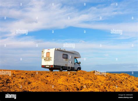 Camper Car On The Rocky Coast Of The Ocean Camper Van Parked Along The
