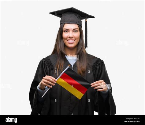 Young Hispanic Woman Wearing Graduated Uniform Holding Flag Of Germany