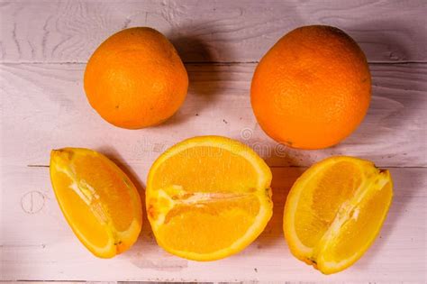 Whole And Sliced Oranges On A Wooden Table Top View Stock Photo