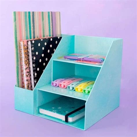 A Blue Desk Organizer With Books Binders And Papers In It On A Purple